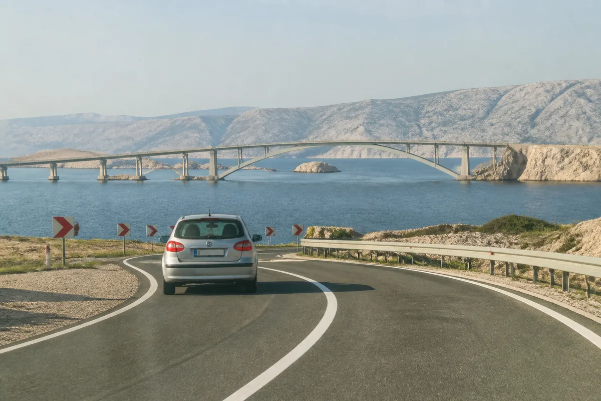Pont reliant l’île de Krk au littoral croate avec une voiture approchant la chaussée